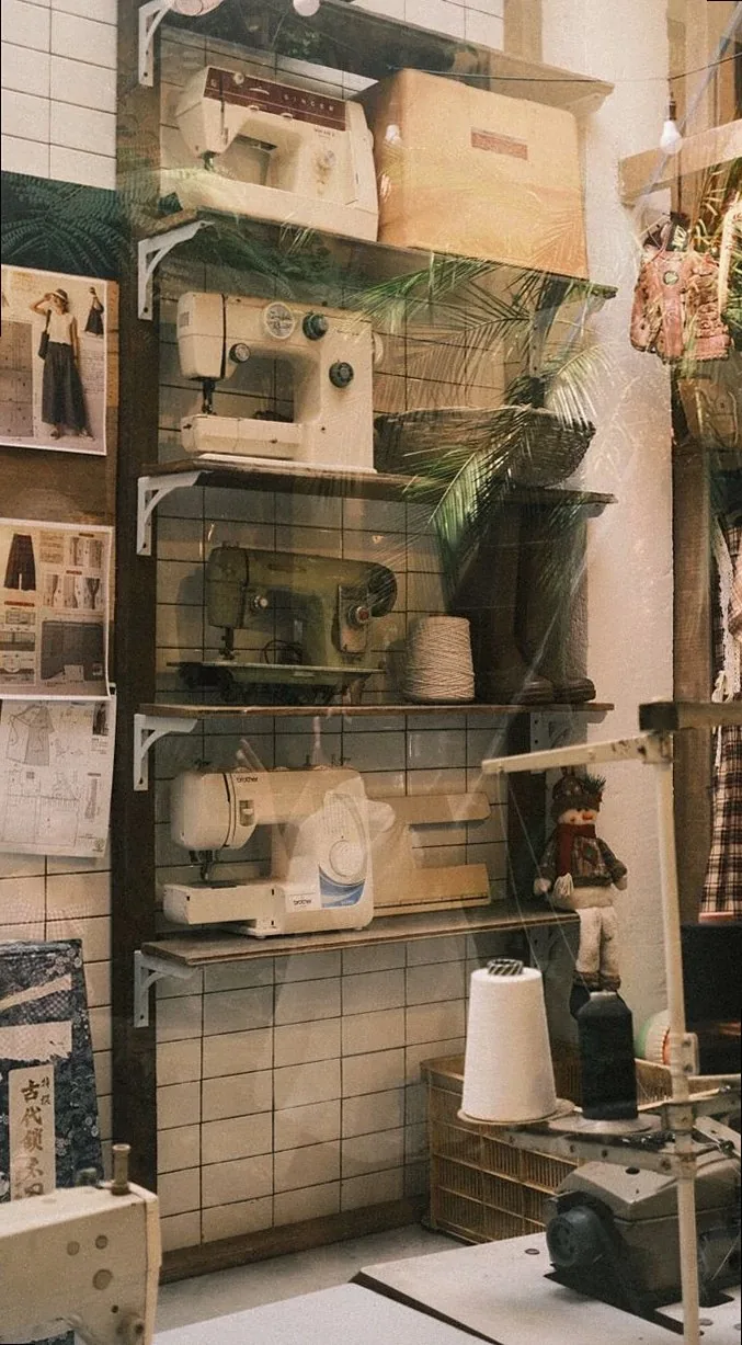A collection of vintage sewing machines on display in a cozy, retro-style tailor shop.